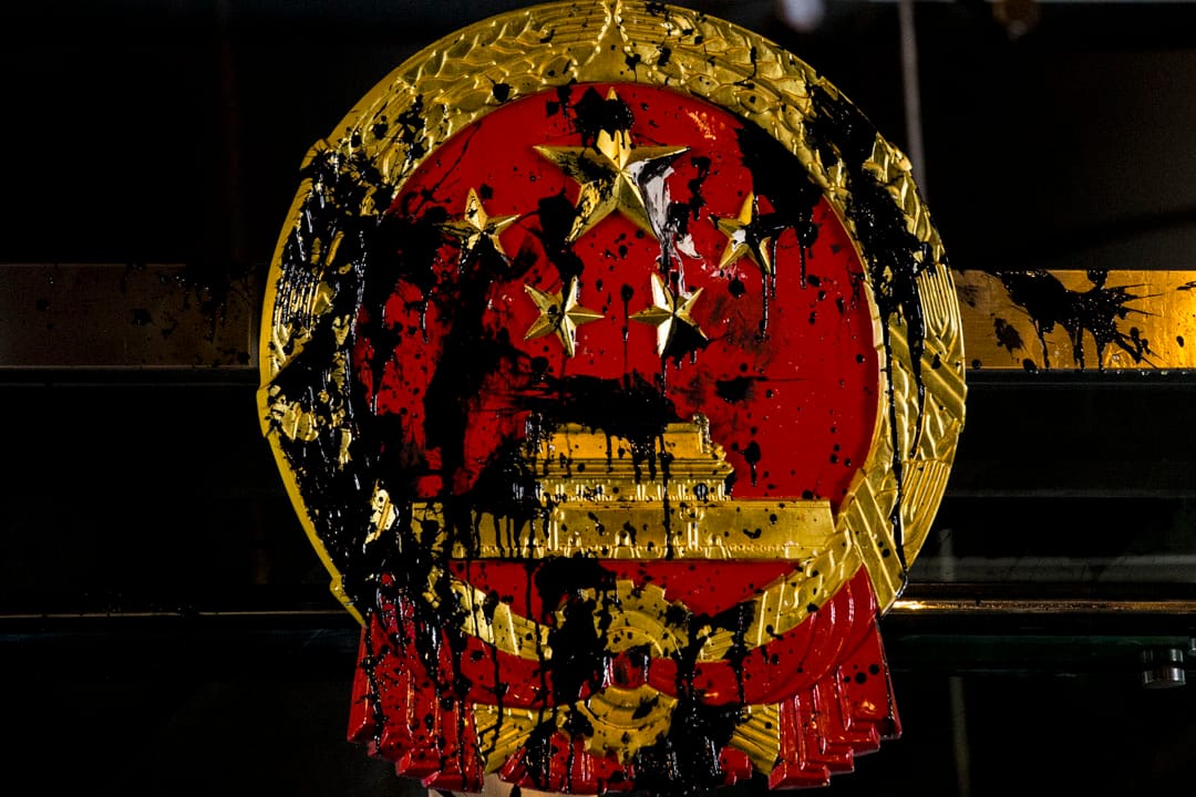 2019年7月21日，示威者到西環的中聯辦集結，門外的中國國徽被漆彈染黑。