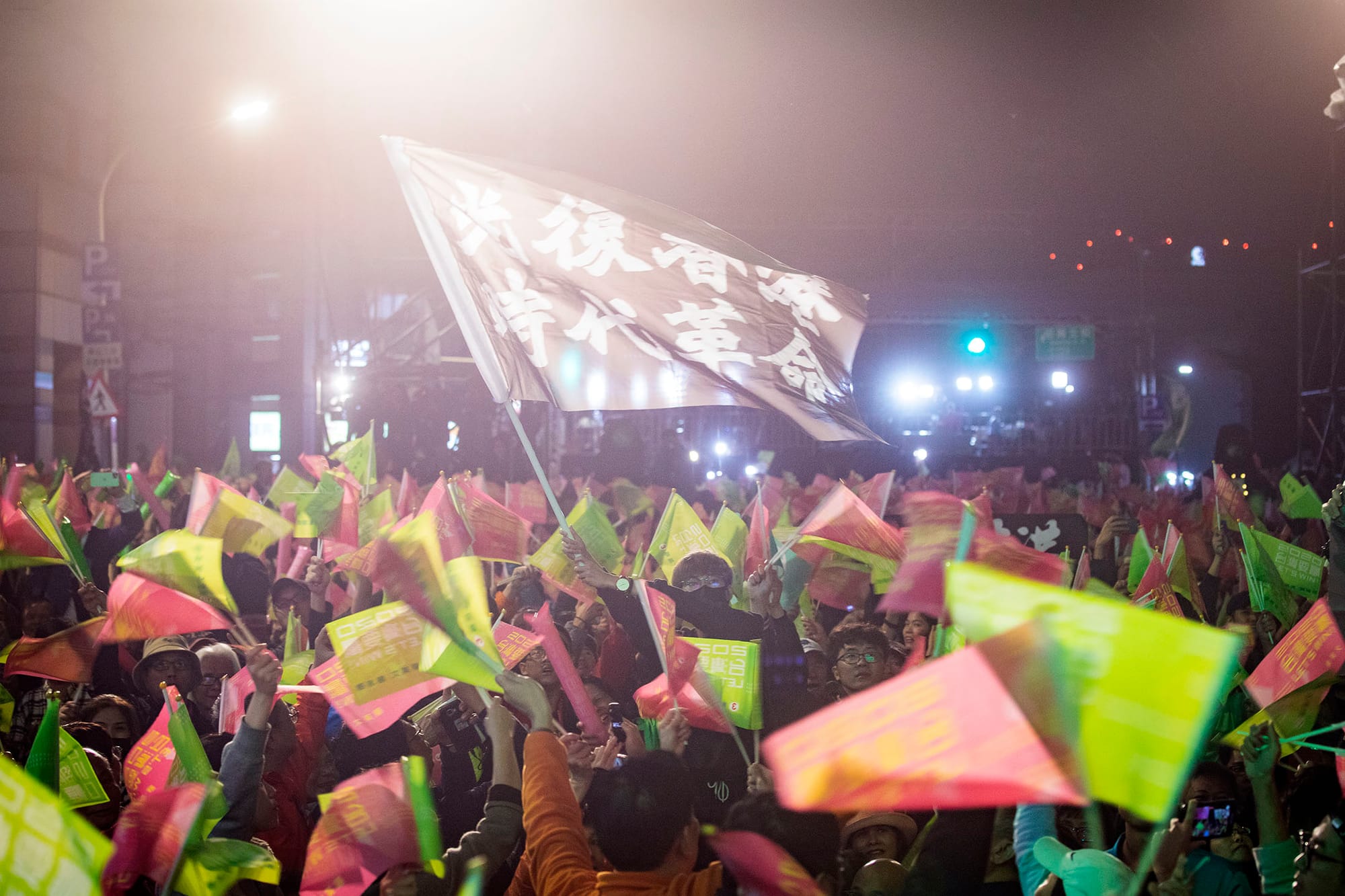 2020年1月11日台北,民進黨的開票晚會上,一名參與者高舉「光復香港時代革命」的旗幟。