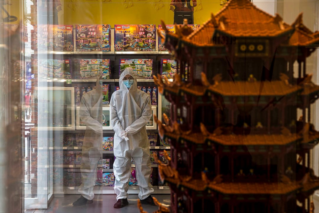 武汉汉街，店员穿防护服守在门口，等著为进门的顾客测量体温。 