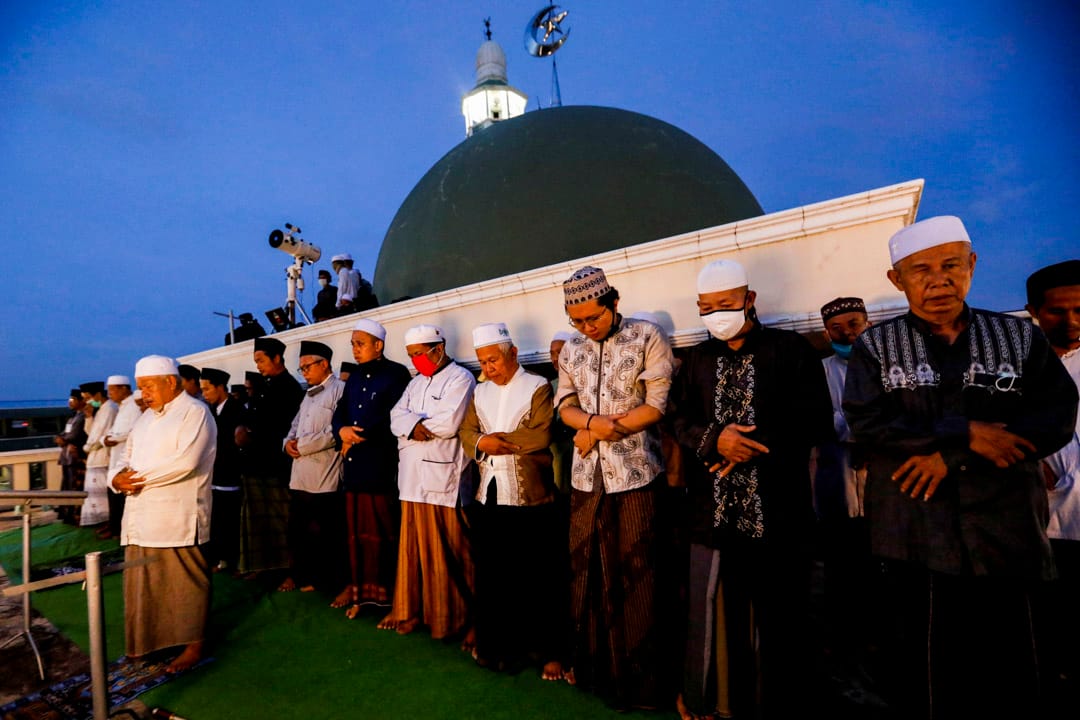 2020年4月23日，印尼雅加达，穆斯林男子于斋戒月的第一天在清真寺的屋顶上祈祷。