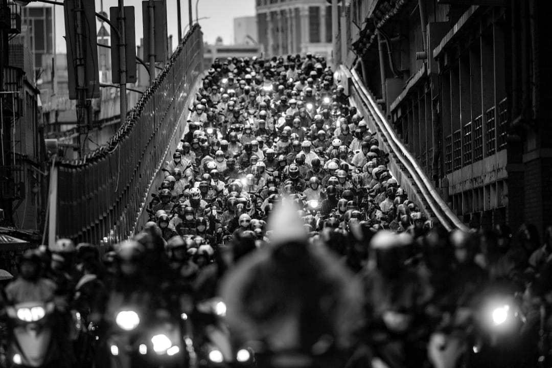 2020年3月21日台北，每天早上市民騎著機車由三重方走向台北，於疫情不算嚴重的台灣，不少市民照常上班。