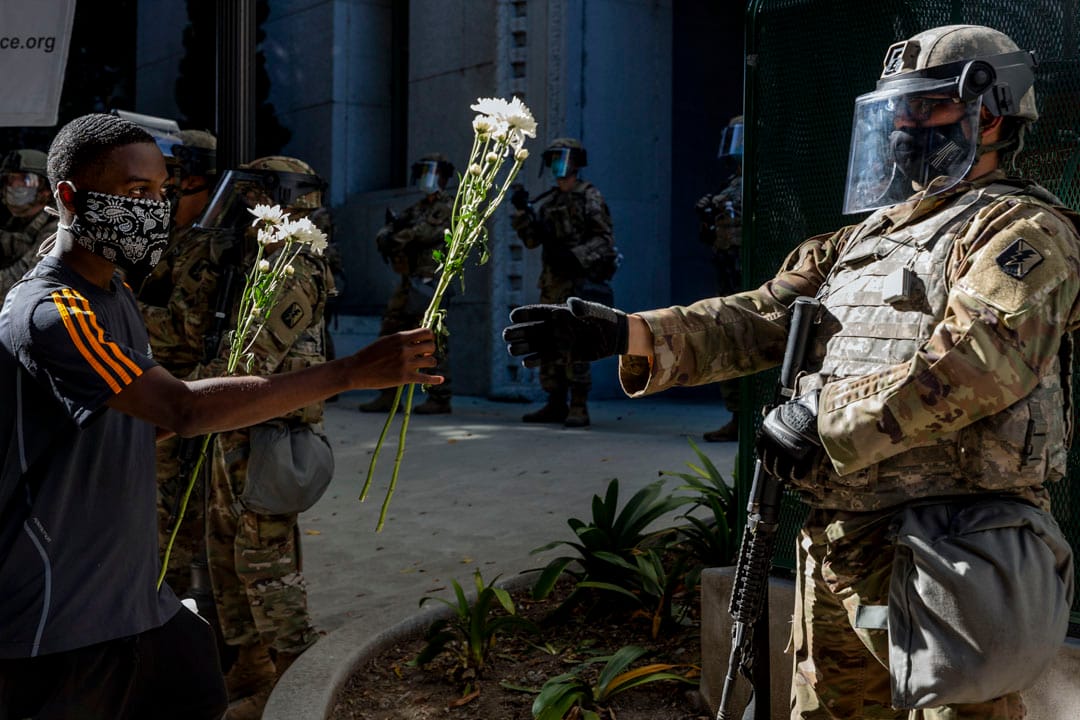 2020年6月3日,洛杉矶一名示威者将鲜花递给国民警卫队员。