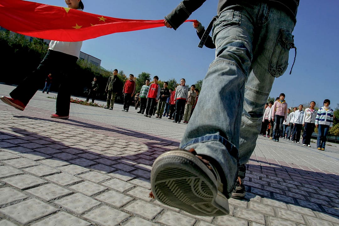 2005年10月14日,新疆维吾尔自治区乌鲁木齐市以北约150公里的昌吉市,学生们在在一所中学练习升旗仪式。