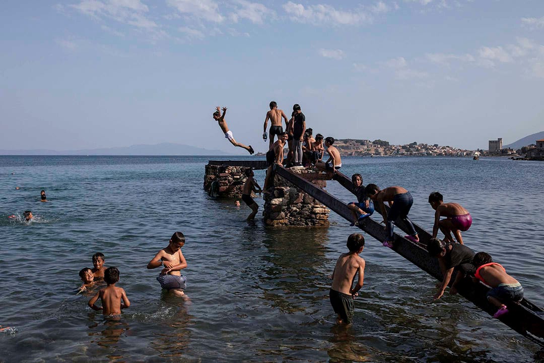 2020年9月12日，希臘萊斯沃斯島，被毀的莫里亞難民營的孩子在海邊跳水。