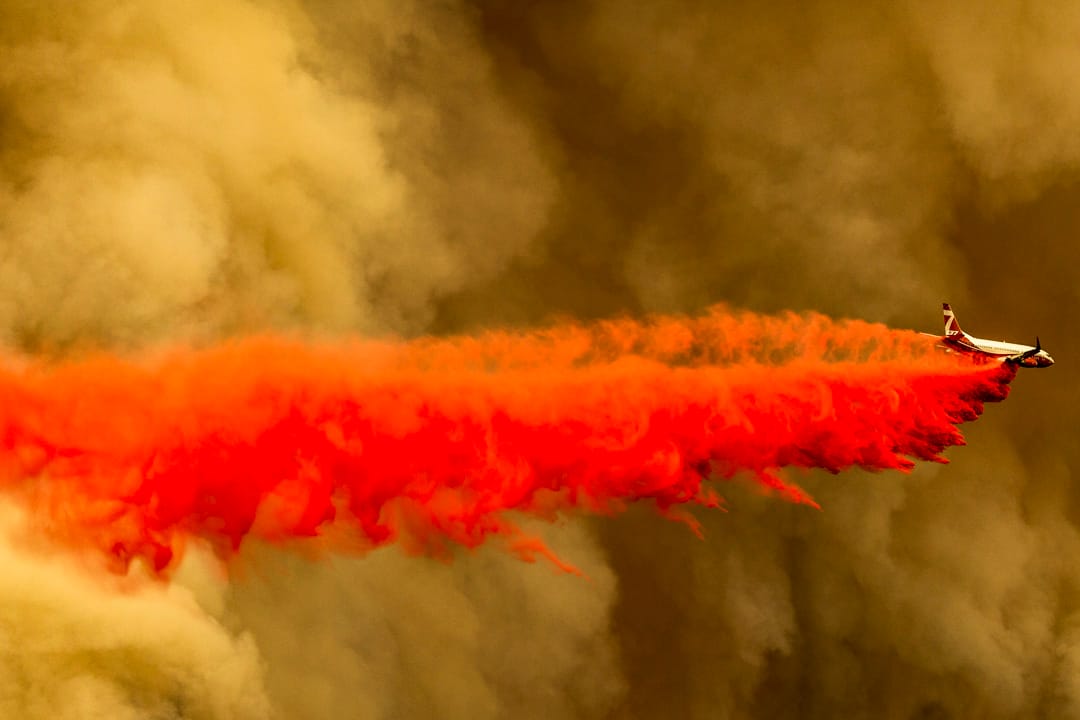 2020年9月10日，美国加州，一架消防飞机在山火火场上空投放阻燃剂。