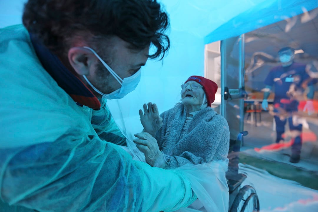 2020年12月21日，意大利一家老人院，一個男人通過塑料薄膜擁抱他的祖母。