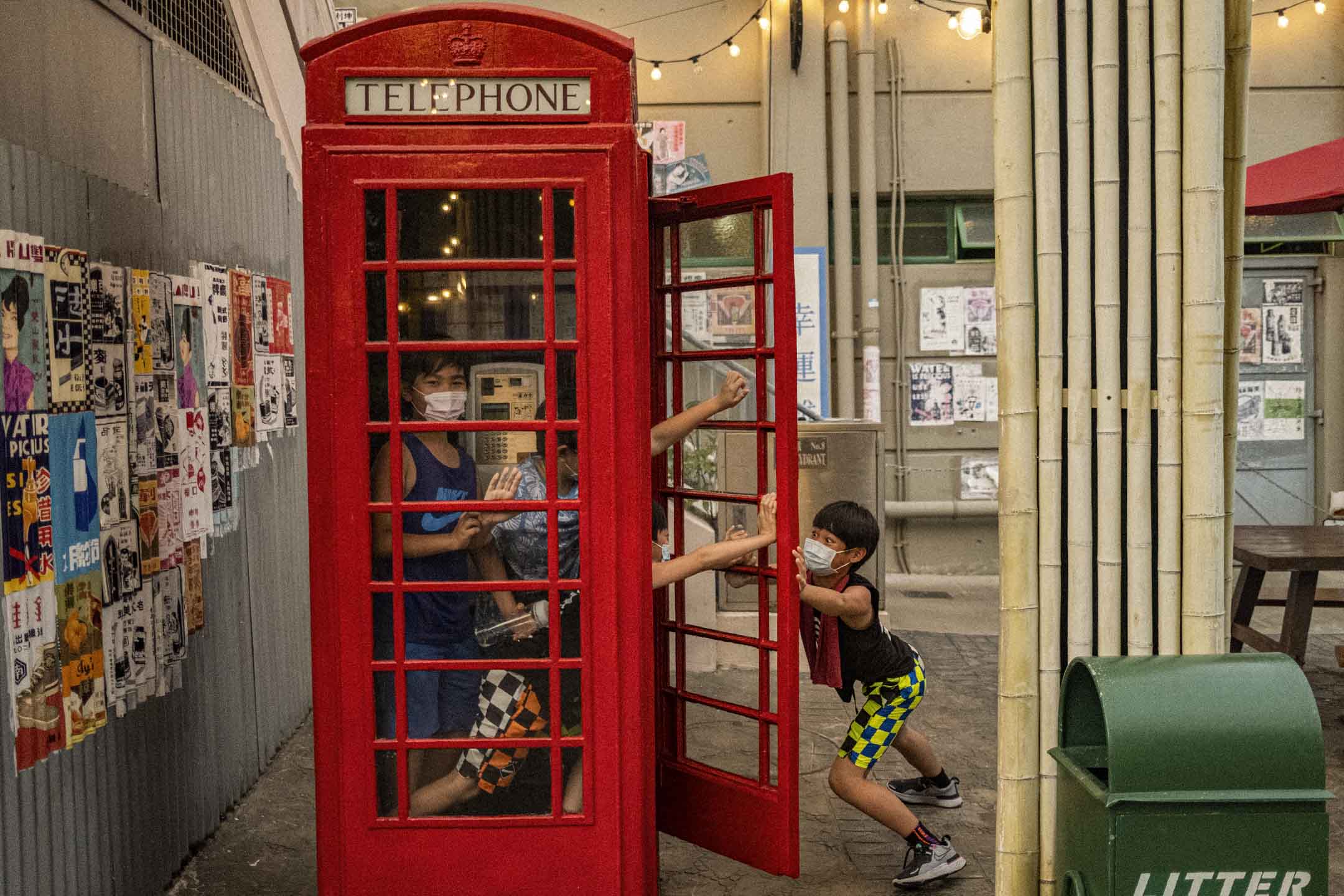 2021年4月1日,孩童在香港老大街的電話亭内玩耍。