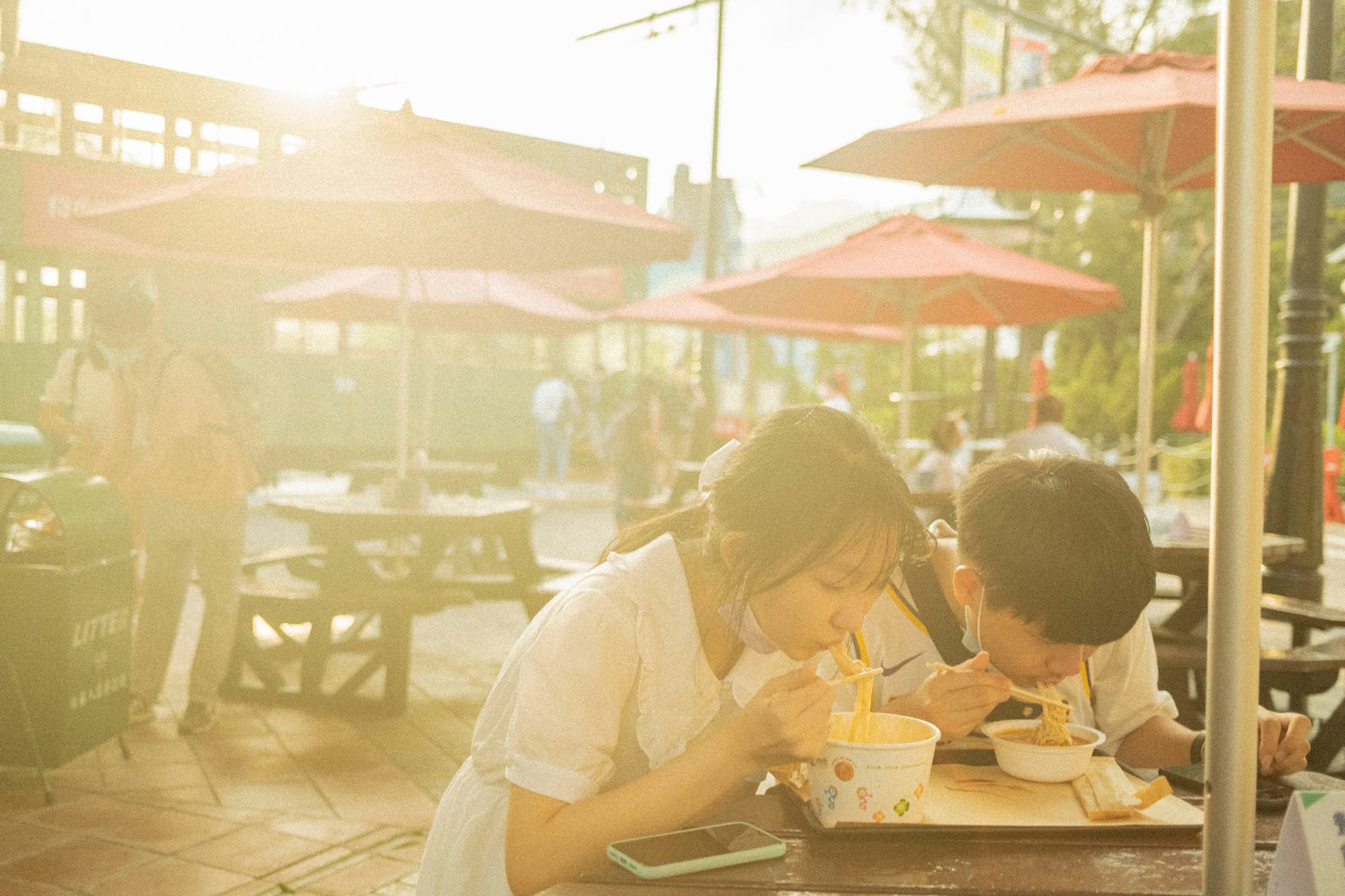 2021年4月25日,一對年輕人黃昏時在香港老大街吃東西。