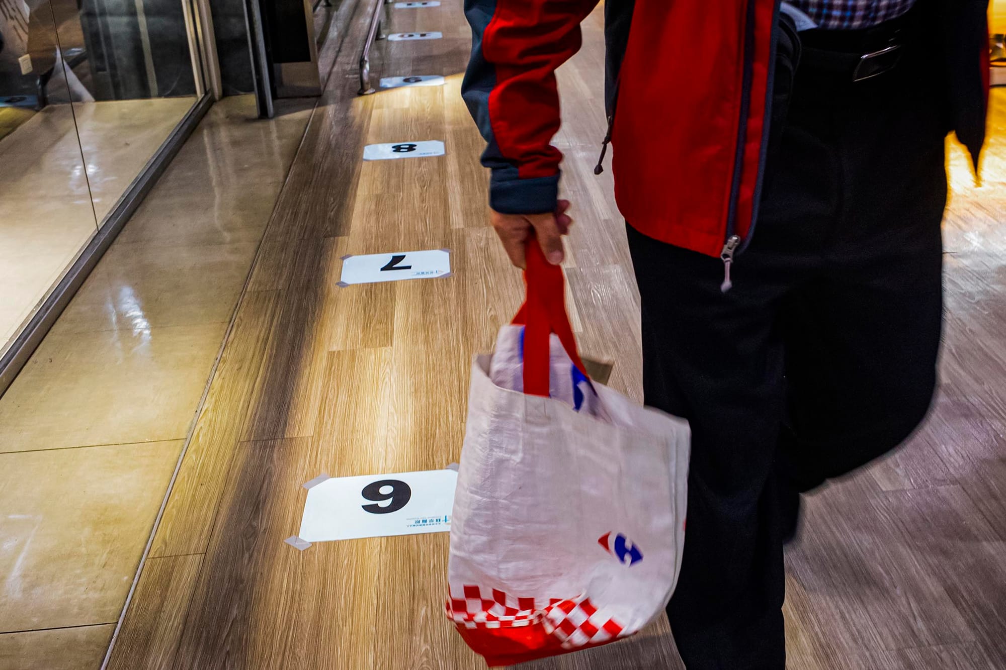 2021年12月10日新店家乐福，商场的地上贴上排队打疫苗的标示。