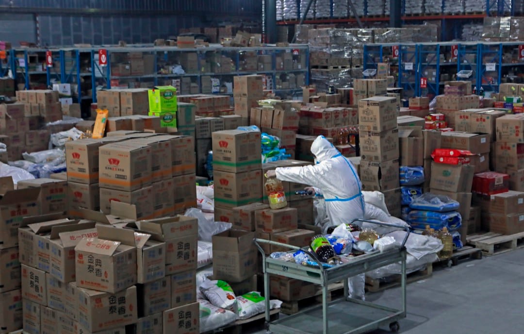 2022年1月10日，中國城市西安，一名穿著保護衣的工作人員在網購公司京東的貨倉內整理貨物。