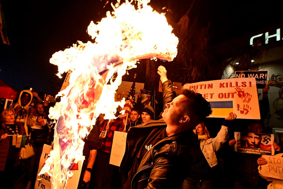 2022年2月24日，美国加利福尼亚州，一名男子在大通银行前举行反对俄罗斯入侵乌克兰的示威，并焚烧俄罗斯国旗。