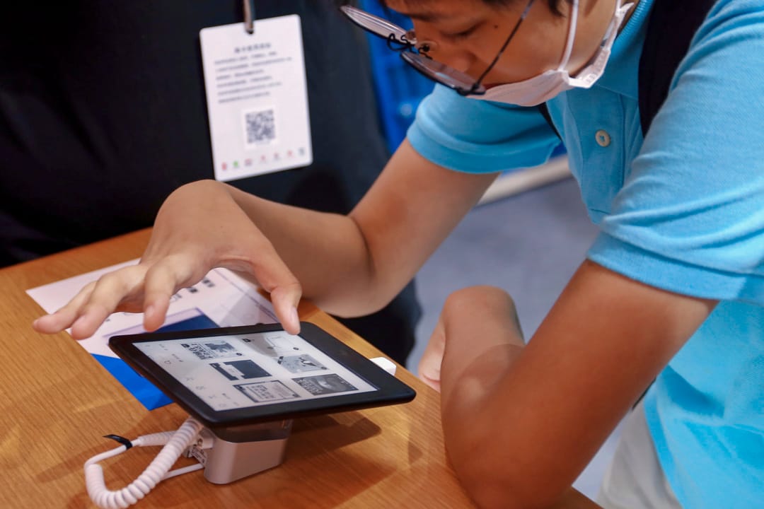 2020年8月12日，一位顧客在上海書展的Kindle攤位試閱電子書。