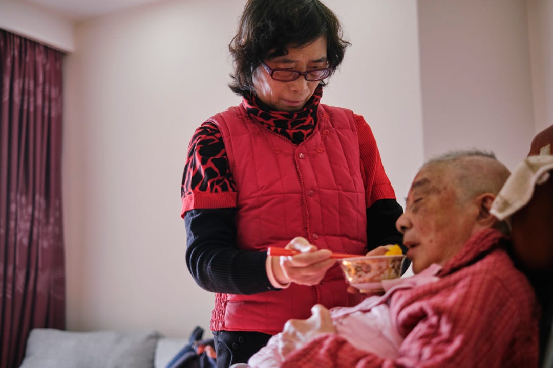 洗浴过后的下午，朱和珍喂母亲陈菊清吃水果和点心。
