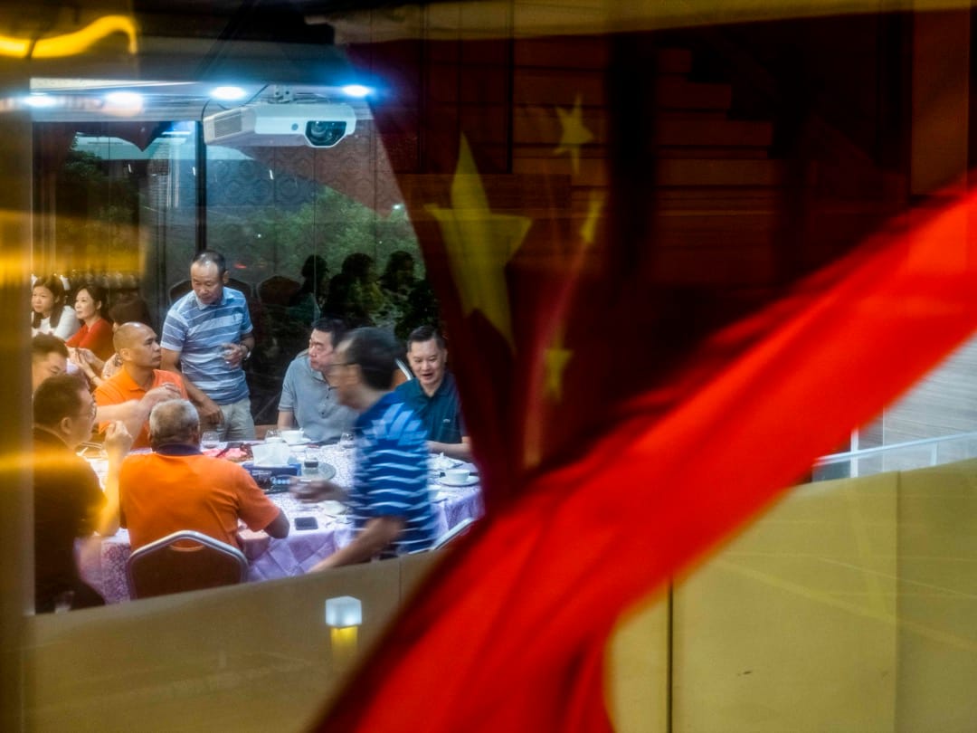 2022年6月26日，食客在尖東一間酒樓晚宴，窗外有一幅國旗在風中飄揚。攝：林振東/端傳媒