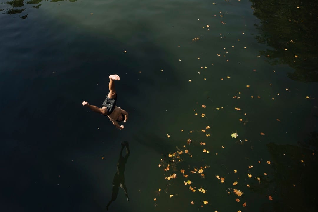 2022年7月18日,法国巴黎,一名小孩从桥上跳进圣马丁运河。