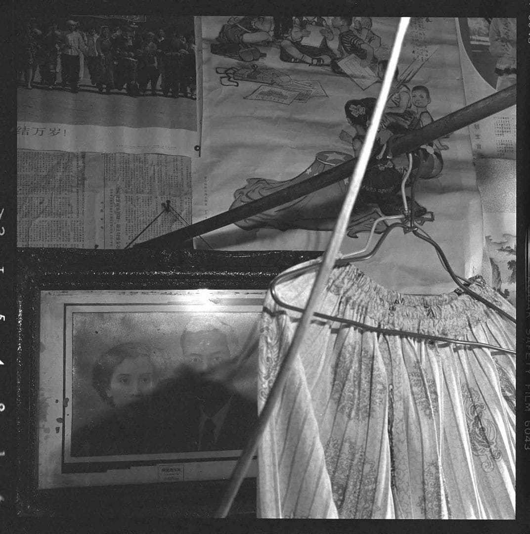 1981年﹐广州家庭,墙上《全国人民大团结万岁》宣传画、《捎个信儿给台湾小朋友》宣传画、民国时的结婚照、糊墙的《参考消息》。