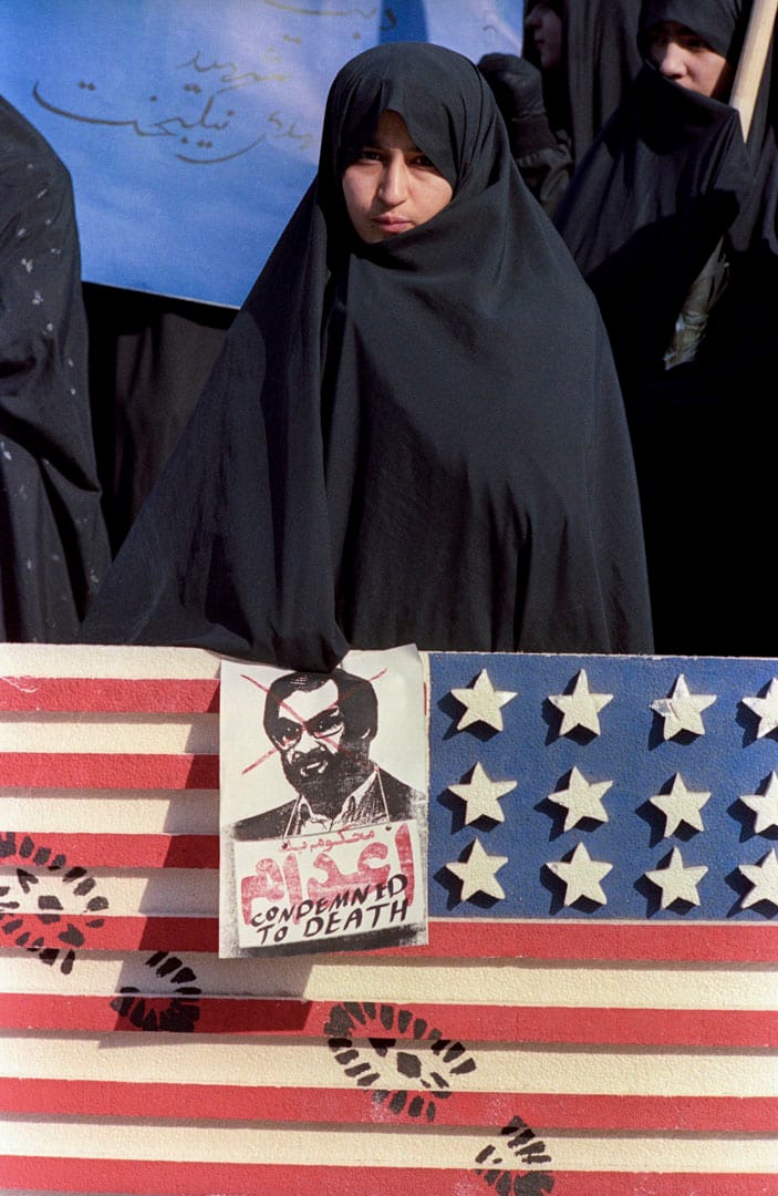 1989年，伊朗德黑兰一名女子手持一张杀死萨尔曼·拉什迪 (Salman Rushdie) 的海报抗议。