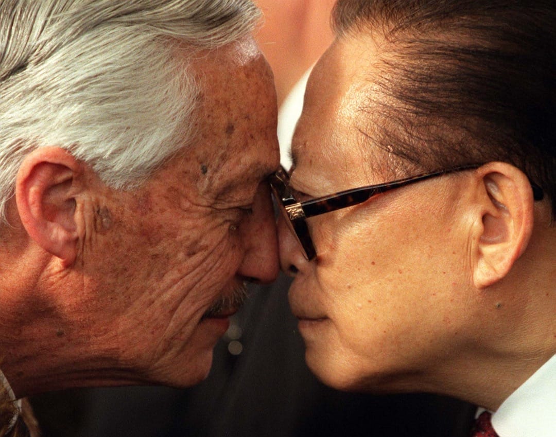 1999年9月12日,紐西蘭首都奧克蘭,中國國家主席江澤民在亞太經合組織會議的歡迎禮上與紐西蘭原住民毛利人長老Sir Hugh Kawharu進行傳統的見面禮儀。