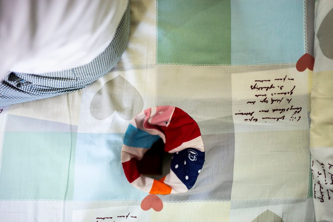 David工作的一張按摩床，床單是淺色的格子，印有灰色的心形圖案。