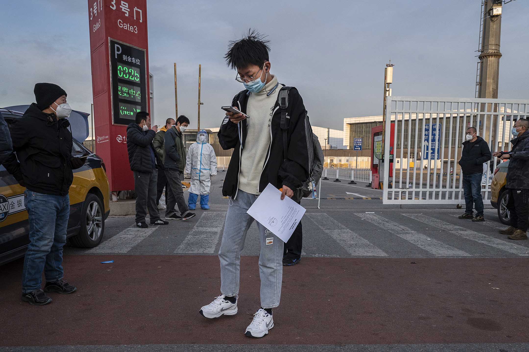 2022年12月7日,北京,一名男子携带政府的文件从隔离的地方离开。