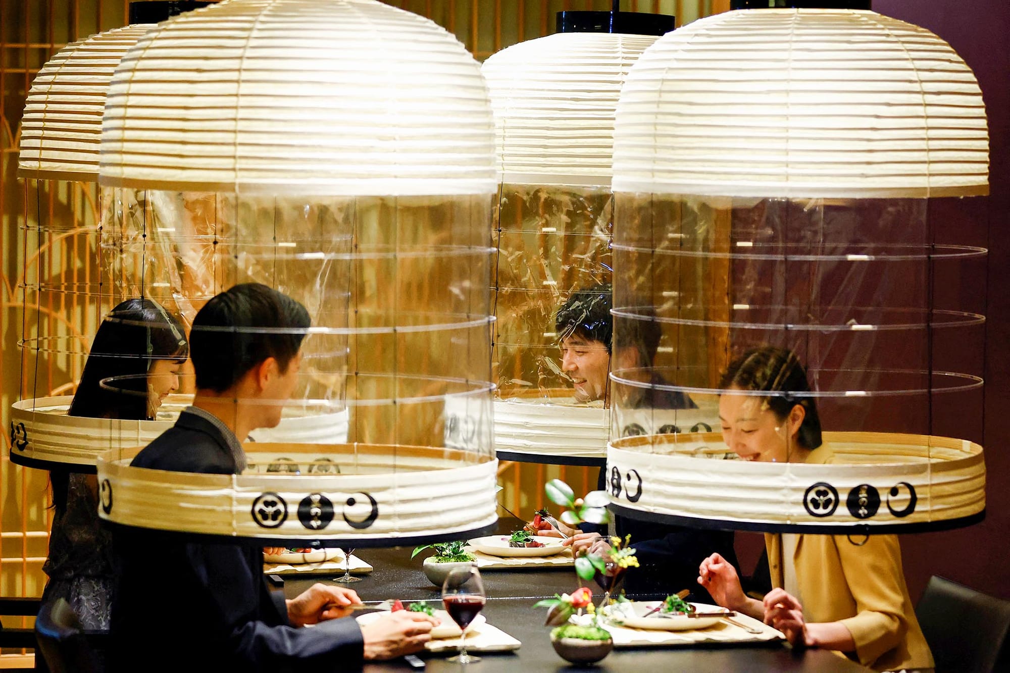 2022年2月2日，日本东京酒店的工作人员示范“灯笼下用餐”，食客在享受美食同时也保护自己，免受2019冠状病毒感染。