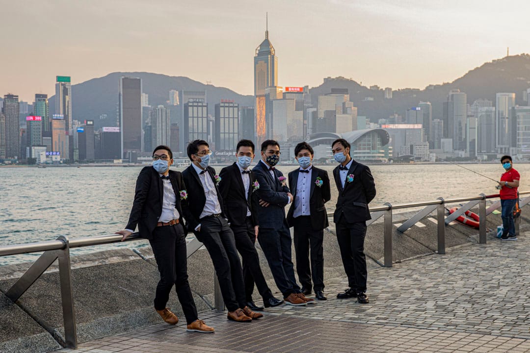 2020年11月1日，尖沙咀，新婚新郎和兄弟们戴著口罩在维多利亚港海旁等待拍照。