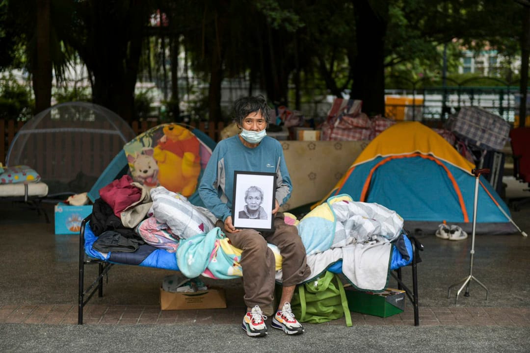 2022年3月31日 无家者周雄光手执“表哥”马月荣遗照。马月荣不幸于无家者告政府案裁决前病逝，无缘见证胜诉时刻。