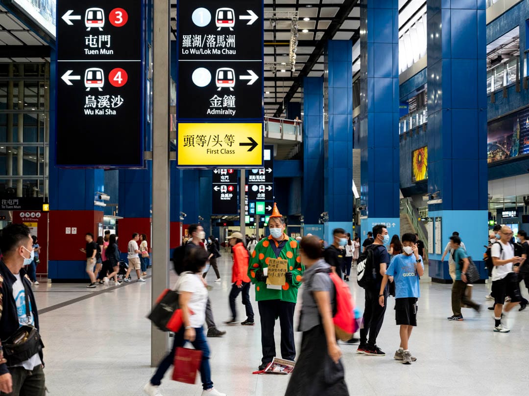 2023年5月1日，程展纬在大围港铁站，穿上cosplay清洁龙和垃圾虫的衣服。他手持纸皮制的标语，为市民当一天“真人图书馆”。摄：林振东/端传媒