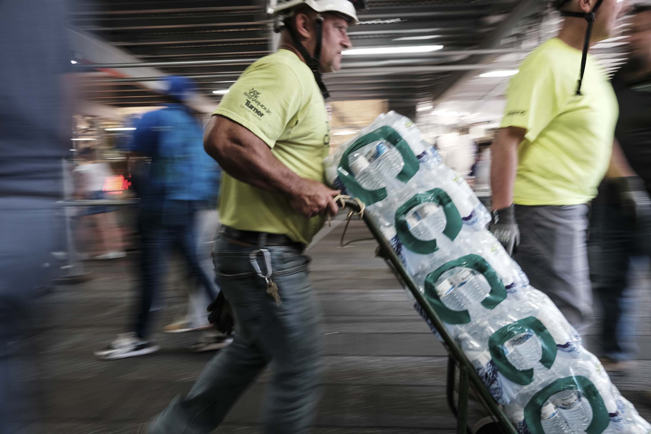 2023年7月6日,美国纽约,一名工人在炎热天气下搬运瓶装水。摄:Spencer Platt/Getty Images
