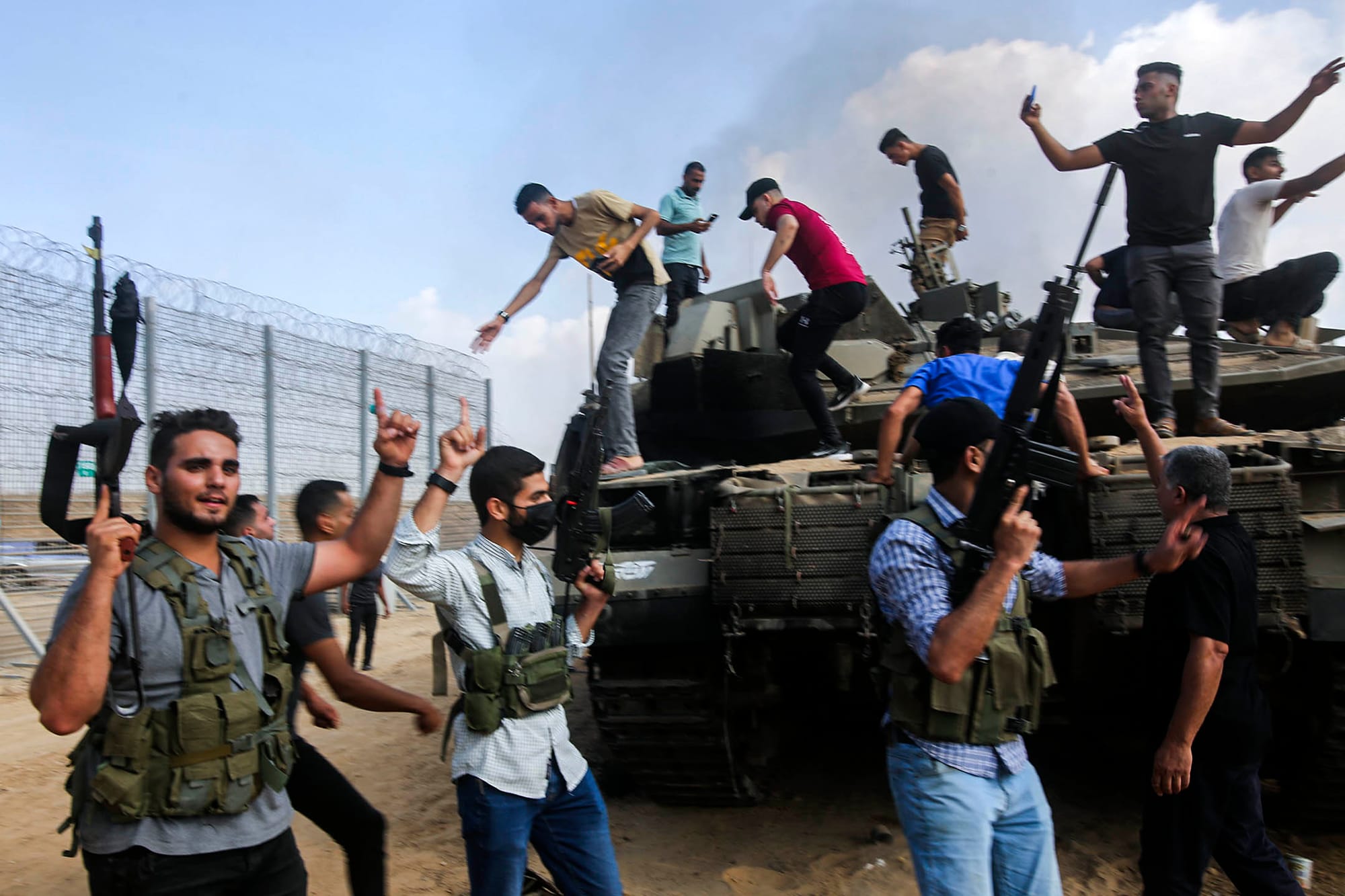 2023年10月7日,巴勒斯坦武装分子在加萨走廊边境站在以色列的坦克上庆祝。摄:Hatem Ali/AP/达志影像