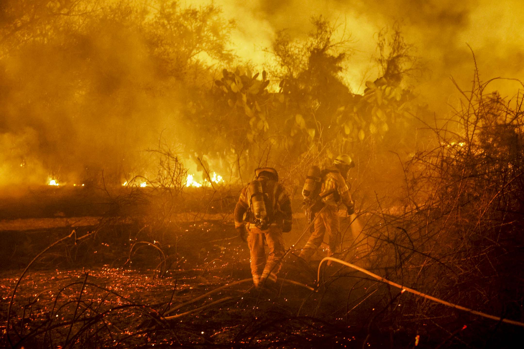 2023年10月7日,以色列南部阿什凯隆一家医院附近因哈马斯袭击起火,消防员正在灭火。摄:Amir Cohen/Reuters/达志影像