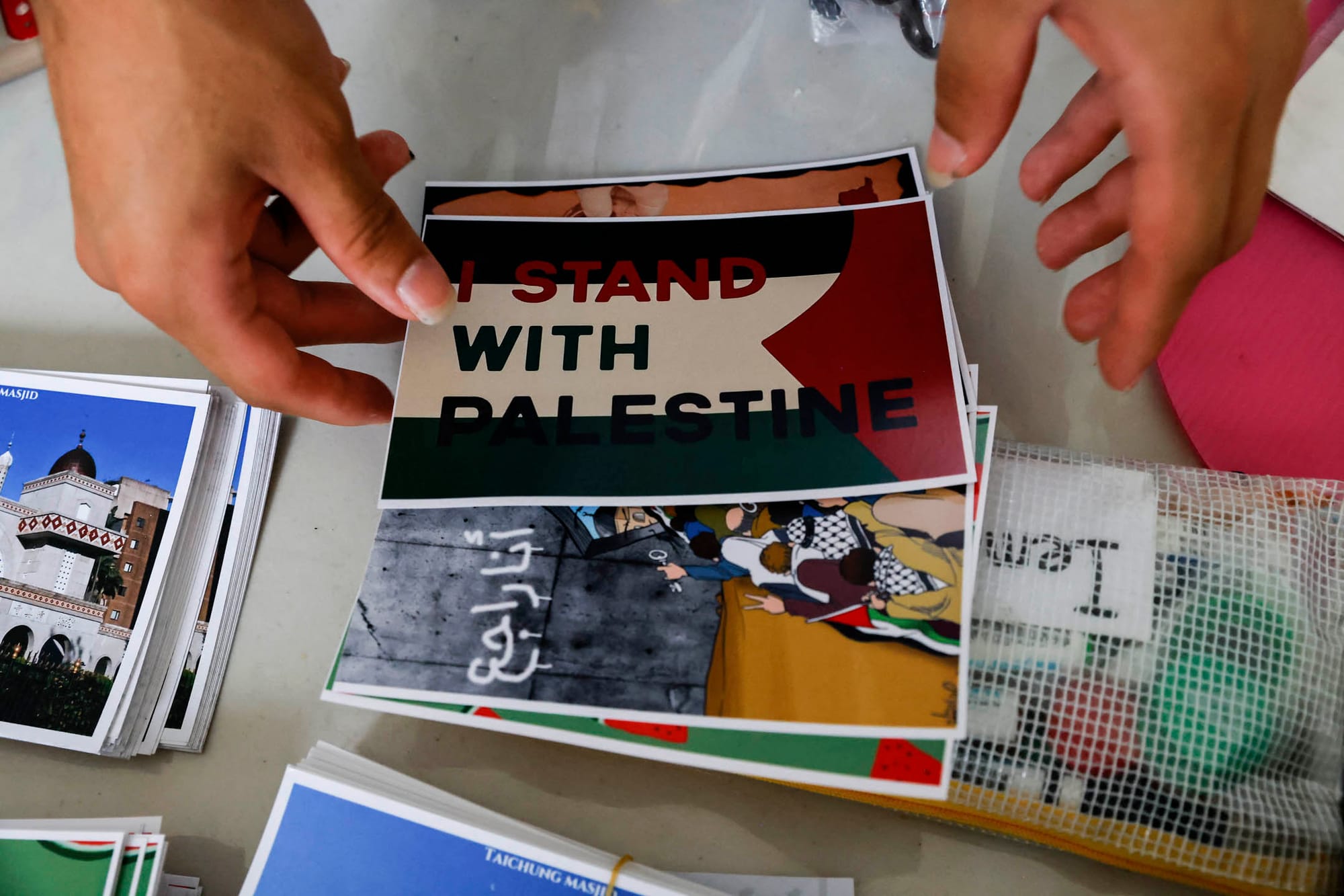 2023年10月21日,一名志工在台灣台北清真寺為巴勒斯坦人舉辦的慈善義賣活動中售賣明信片。攝:Ann Wang/Reuters/達志影像