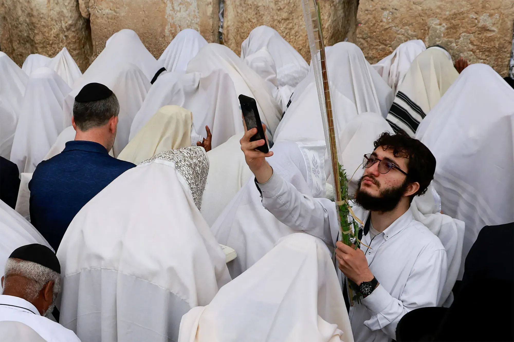 2023年10月2日,耶路撒冷舊城西牆的祈禱地點,一名男子拿著手機拍照。攝:Ammar Awad/Reuters/達志影像