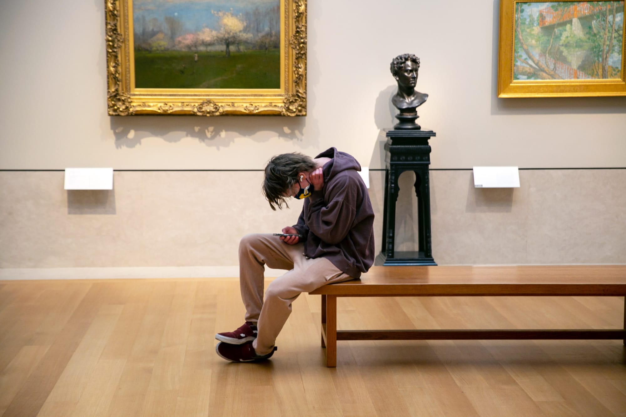 2022年2月20日，美国纽约，一名男子坐在大都会艺术博物馆内看电话。摄： Ted Shaffrey/AP/达志影像