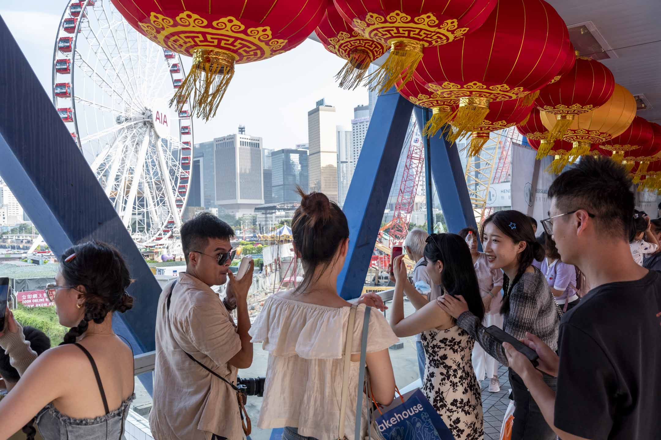 2023年10月5日，十一黃金週期間，內地旅客以中環摩天輪作背景拍照。攝：林振東/端傳媒