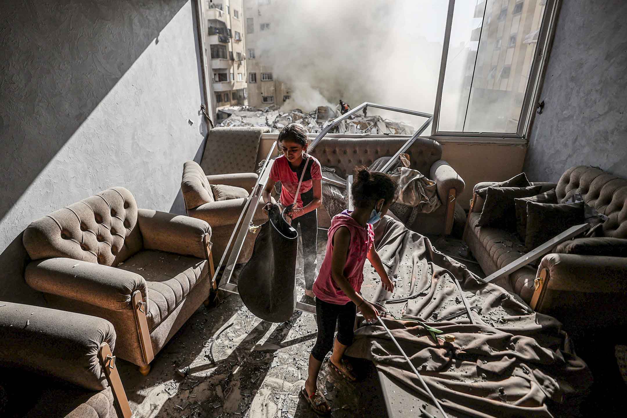 2023年10月7日,以色列对加沙发动攻击后,孩子们在被毁坏的房子里。摄:Mustafa Hassona/Anadolu Agency via Getty Images