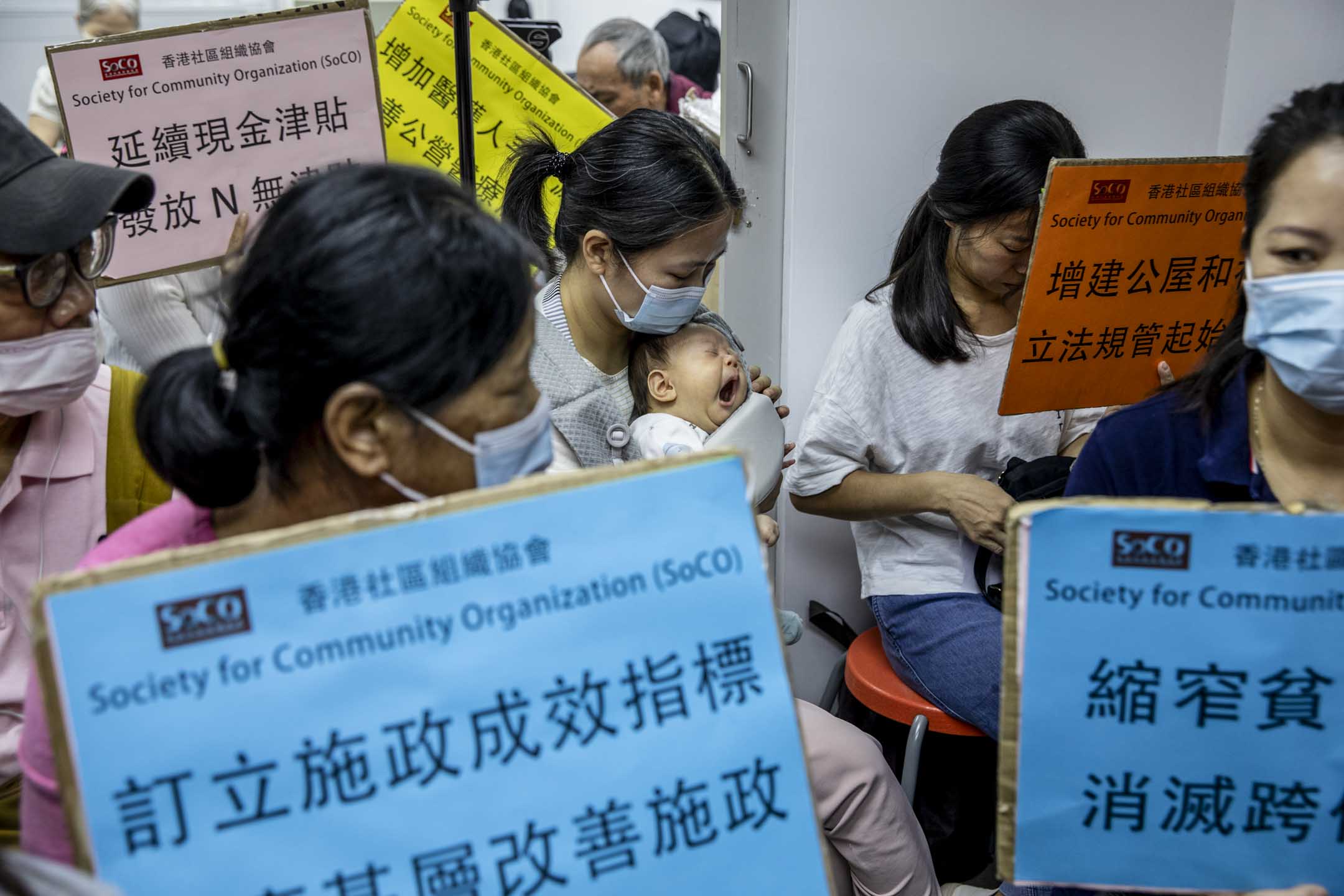 2023年10月25日,香港社协安排基层市民一同收看行政长官宣读本年度的施政报告,其中有市民带同婴孩来观看。摄:林振东/端传媒