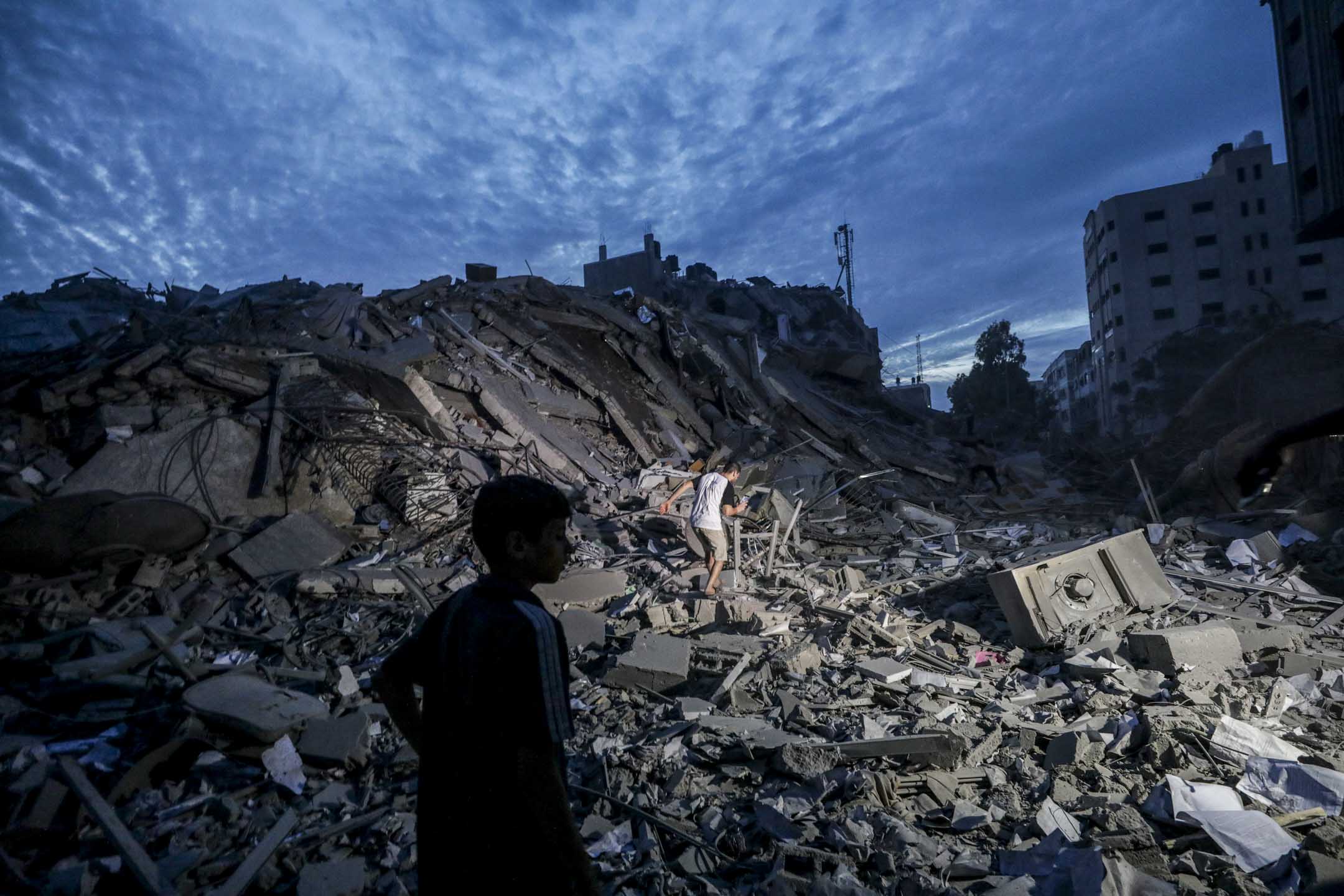 2023年10月7日,以色列反击空袭巴勒斯坦加沙后,当然幸存者在摧毁的废墟寻找剩下的物品。摄:Mohammed Saber/EPA/达志影像