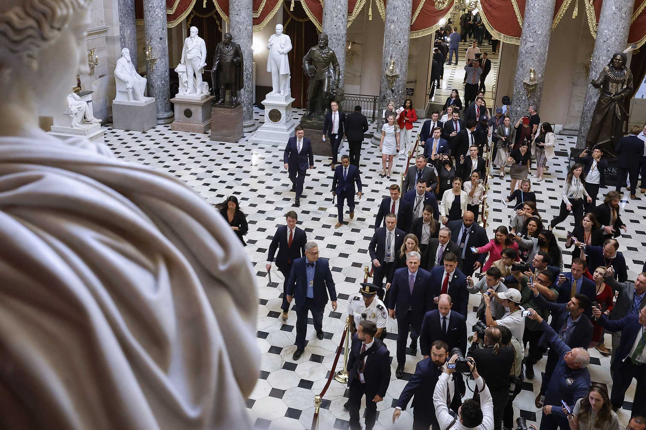 2023年10月3日，前眾議院議長麥卡錫於華盛頓的美國國會大廈被驅逐後走過大廳，圍繞著工作人員、保安和記者。