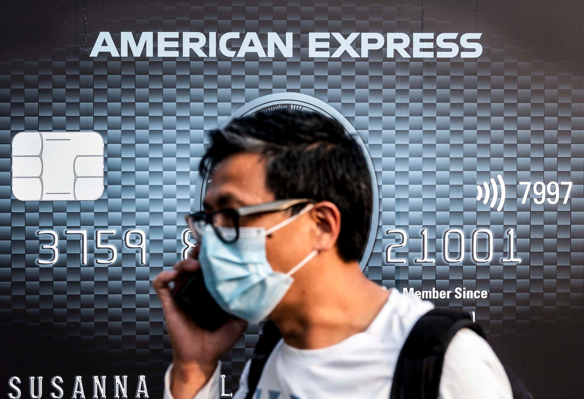 2021年3月15日,一名戴著口罩的行人在美国运通的广告走过。摄:Budrul Chukrut/SOPA Images/LightRocket via Getty Images