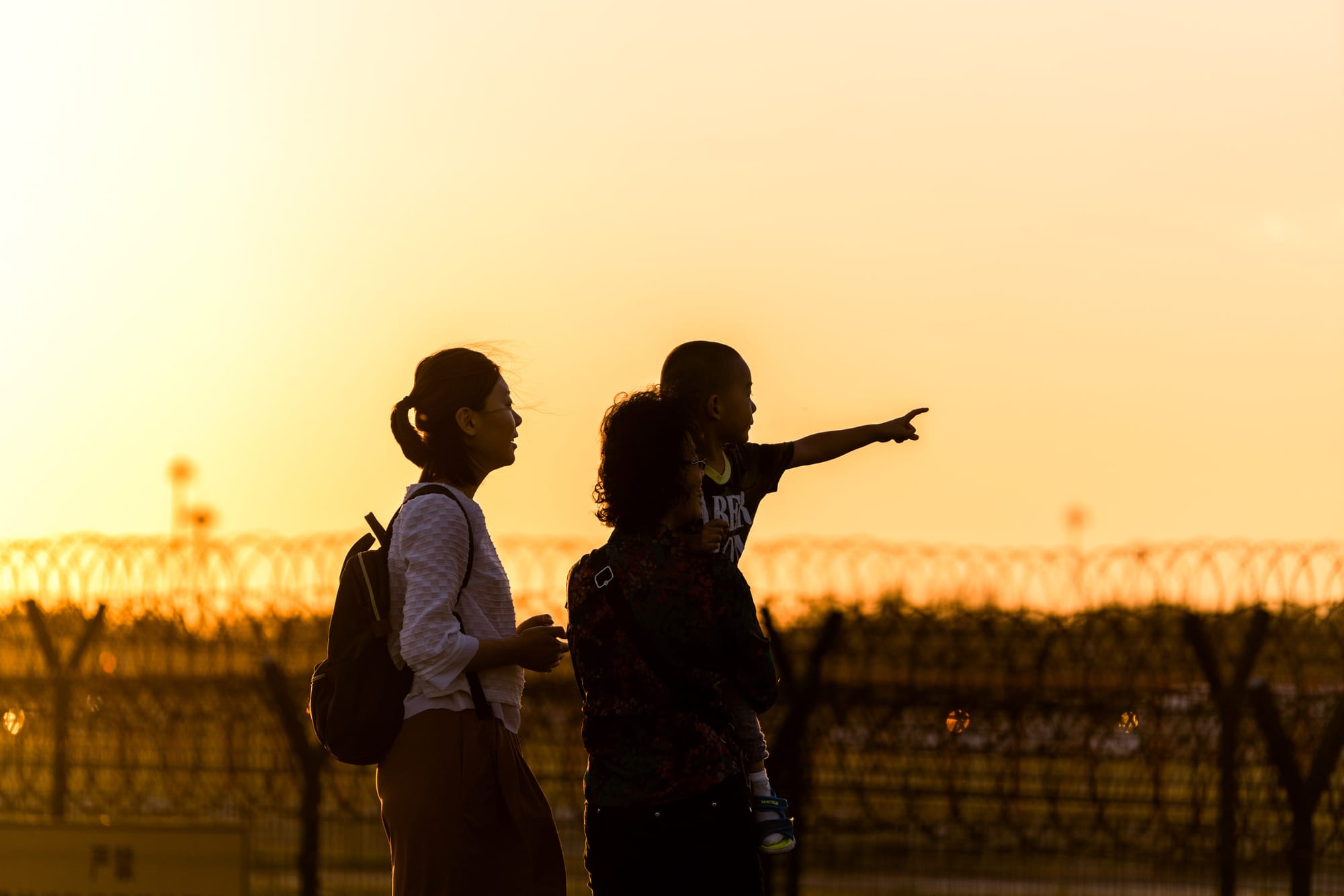 2017年5月24日,中國北京,一個小男孩與母親和祖母在機場觀看日落。攝: Zhang Peng/LightRocket via Getty Images