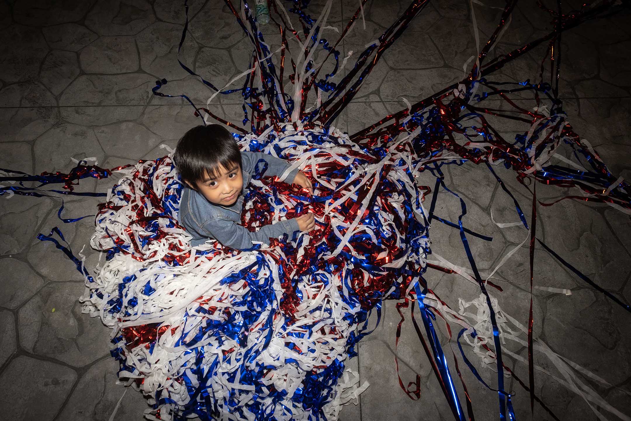 2023年10月24日，新北市，國民黨的造勢大會過後，小孩在彩帶堆中玩耍。攝：陳焯煇/端傳媒