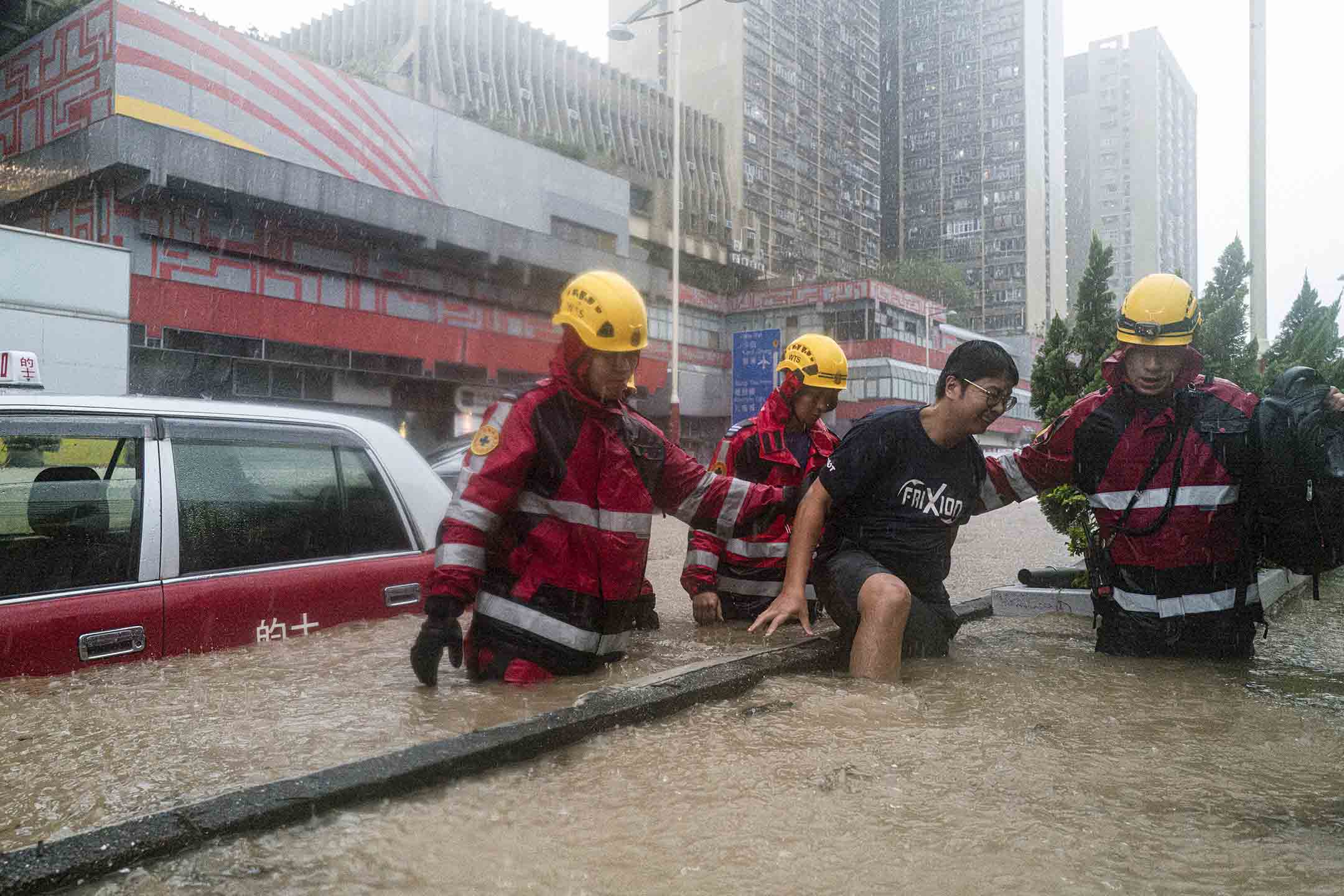 2023年9月8日，香港，消防员在暴雨中救助被洪水围困的市民。摄：Lam Yik/Bloomberg via Getty Images