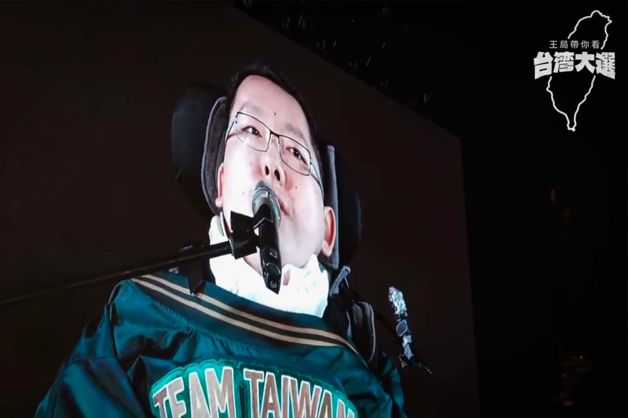 王志安在民进党造势晚会拍摄,萤幕上是民进党不分区立委候选人陈俊翰。图:影片截图