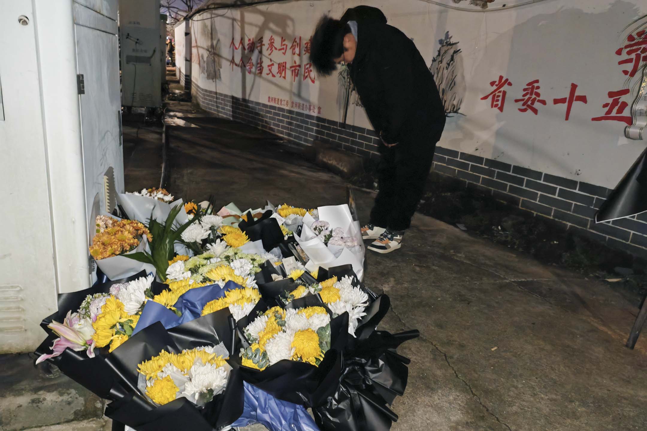 2024年1月25日，中國江西新余市一場大火導致39人死亡後，一名男子在火災現場附近鞠躬哀悼罹難者。攝：VCG/VCG via Getty Images