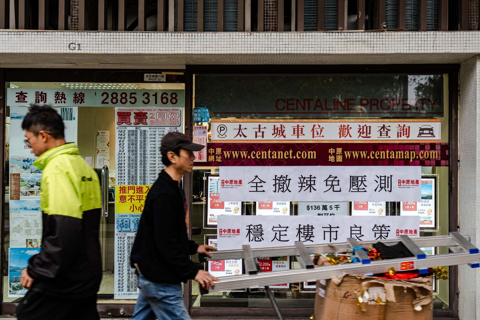 2024年2月28日,政府發布本屆第二份財政預算案,宣布樓市全面「撤辣」後,有地產商在店鋪外貼上歡迎的字句。攝:Ryan Lai/端傳媒