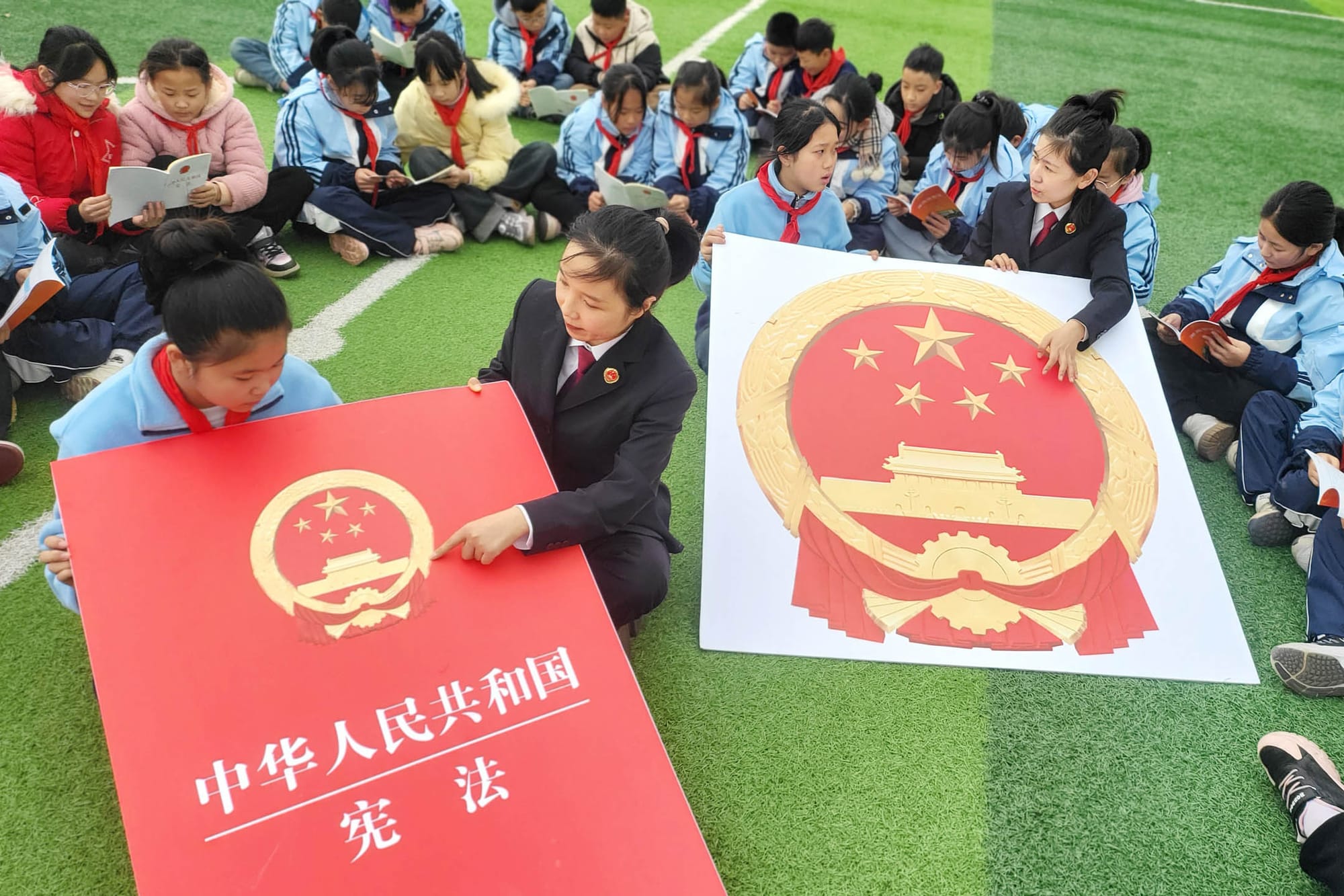 2023年11月30日，中国连云港，一名官方人员正在教授小学生中国宪法。摄：CFOTO/Future Publishing via Getty Image