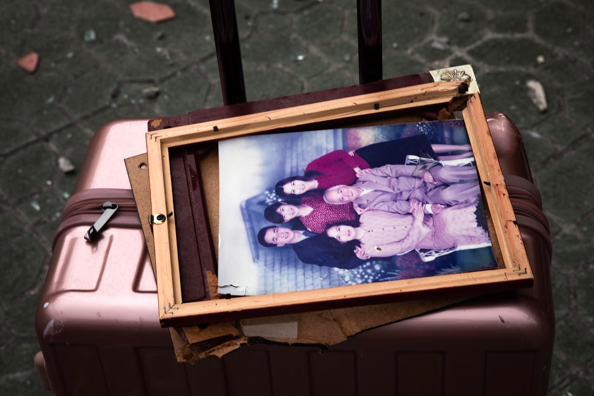 2024年4月5日,居民被迫撤離大廈,行李上有一幅家庭照。攝:陳焯煇/端傳媒