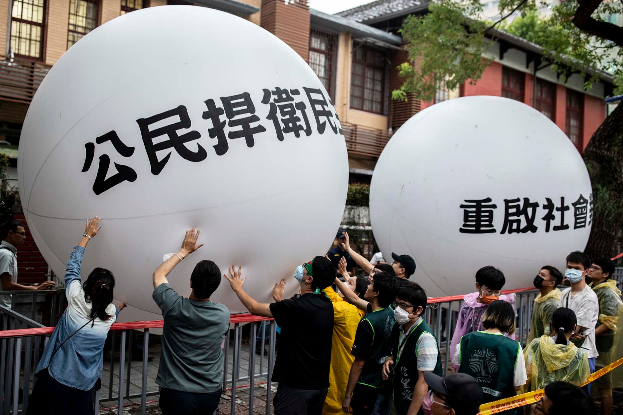 2024年5月28日，台北，立法院进行国会改革法案审议，立法院外有民众集会，抗议民众把写著“公民捍卫民主”、“重启社会对话”的大型气球，接力传递到立法院前，表达这次行动诉求。摄：林振东/端传媒