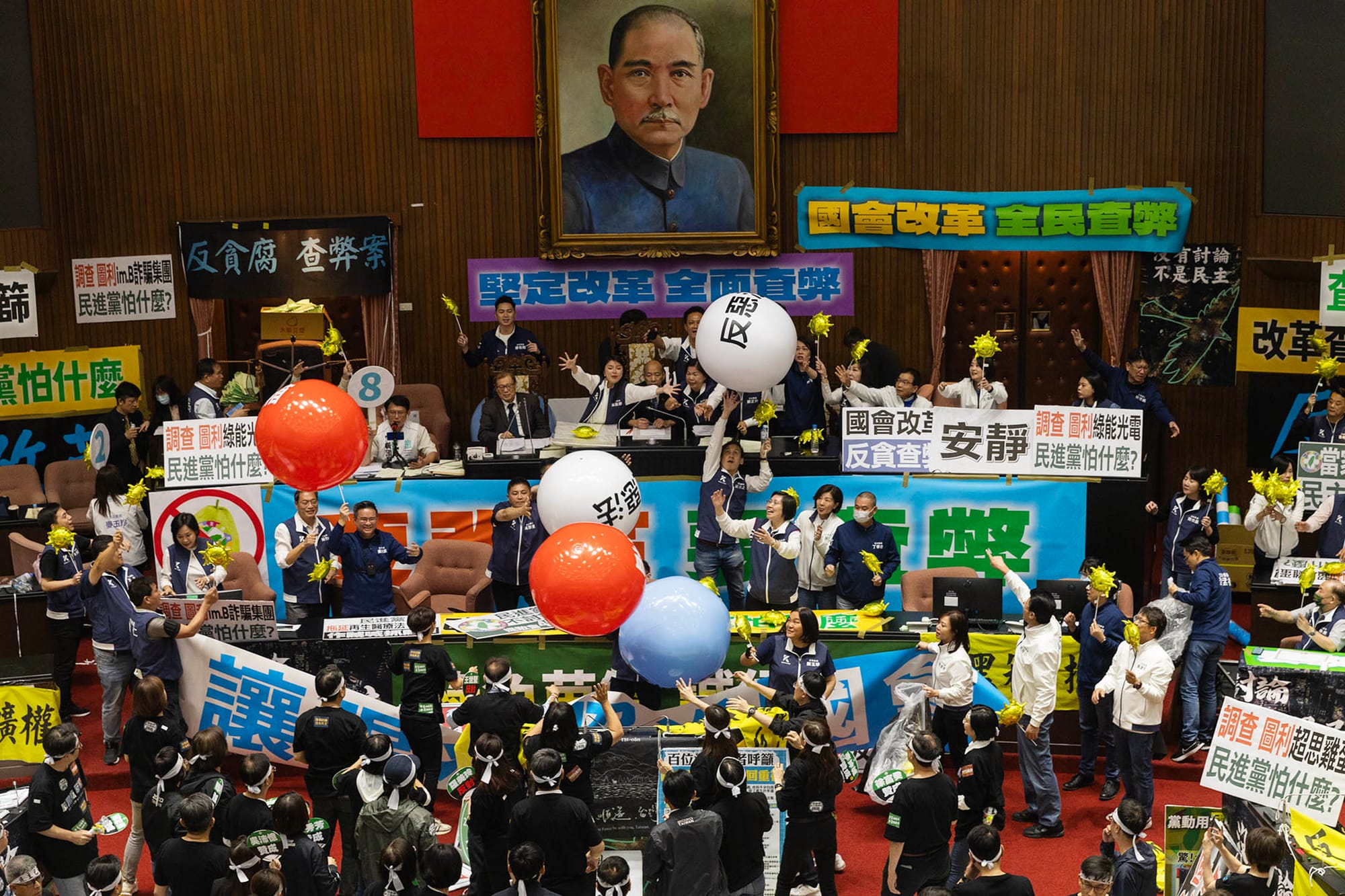 2024年5月28日，台北，立法院進行國會改革法案審議，立法院内民進黨立委向主席台抛汽球。攝：陳焯煇/端傳媒